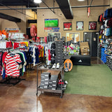 Interior of a retail store with clothing racks, shoes, and shelves.