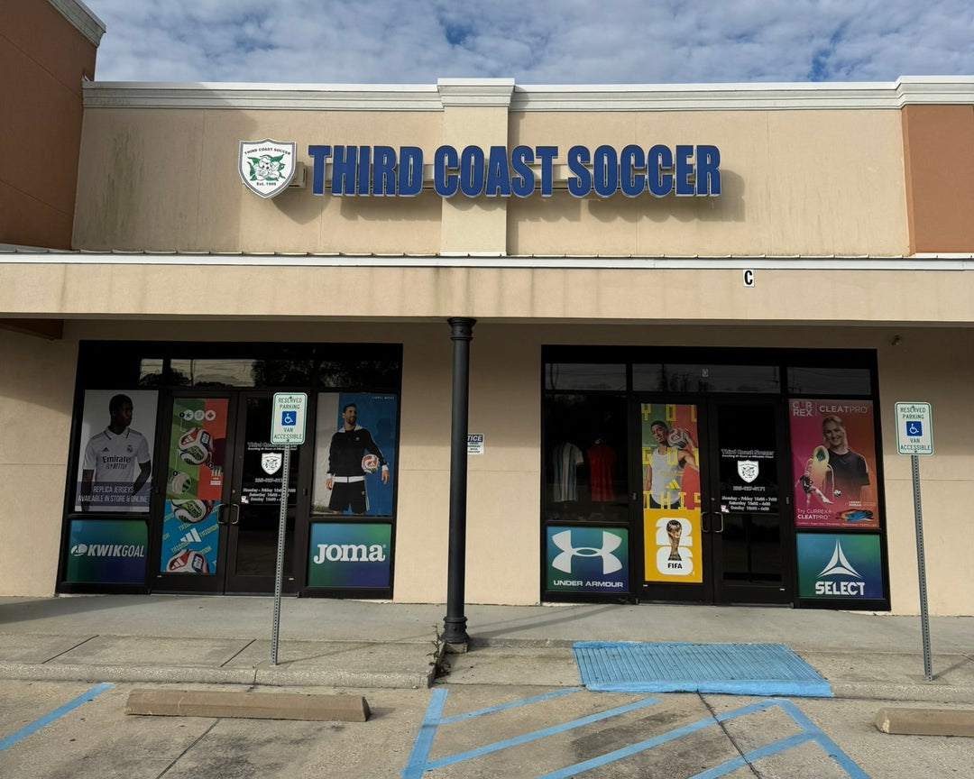 Storefront with 'Third Coast Soccer' sign against a blue sky with clouds