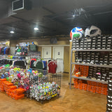 Store interior with sports equipment and merchandise on shelves and racks.